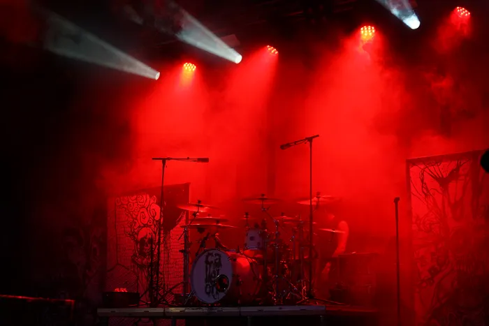 Schlagzeug auf einer Bühne unter intensivem rotem Licht und Nebel bei einem Auftritt der Band Callejon.