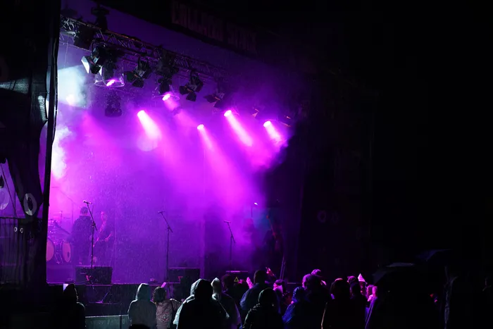 Musiker auf der Collabo Stage unter violettem Bühnenlicht vor einer Menschenmenge.