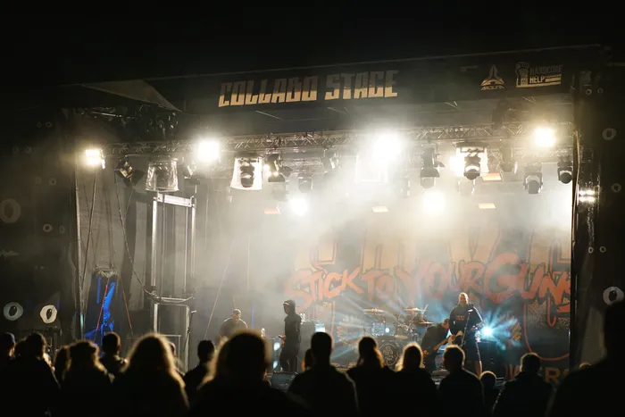 Die Band Stick To Your Guns spielt auf der Collabo Stage vor einem Publikum unter hellem Scheinwerferlicht.