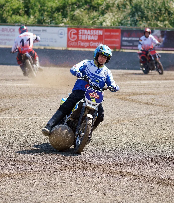 Ein Motorradfahrer mit der Startnummer 8 fährt auf einer staubigen Strecke, während im Hintergrund weitere Motorräder zu sehen sind. Das Derby zwischen dem MSF Tornado Kierspe und dem MBC Kierspe ist im Gange.