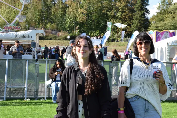 Zwei lächelnde junge Frauen bei dem Festival Bautz 2026 vor einer Menschenmenge und Verkaufsständen.
