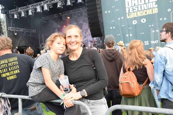 Eine lächelnde Frau und ein Mädchen posieren vor einer Festivalbühne beim Band Festival Lüdenscheid.