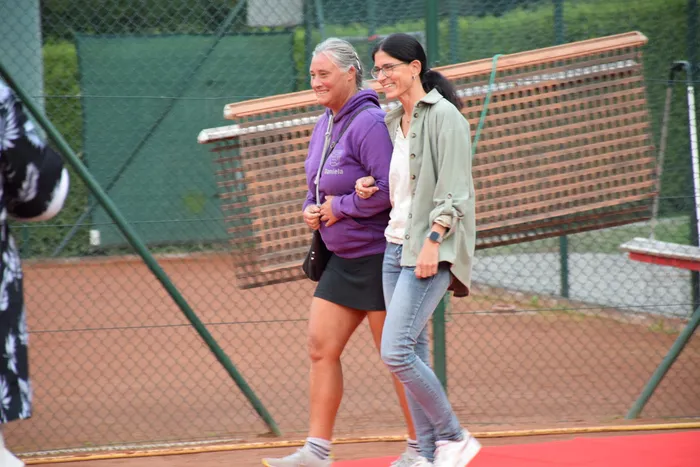 Zwei lächelnde Frauen gehen über einen Tennisplatz während der Jubiläumsfeier der MTC/TC Halver Open.