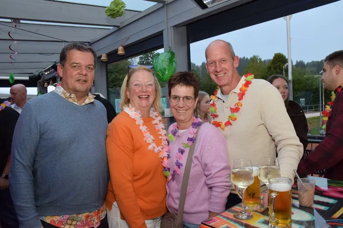 Vier lächelnde Personen mit bunten Blumenketten bei der Jubiläumsfeier der MTC/TC Halver Open.