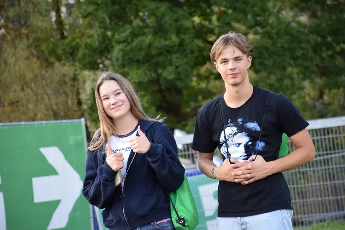 Zwei lächelnde junge Menschen auf dem Bautz-Festival, wobei das Mädchen zwei Daumen nach oben zeigt.