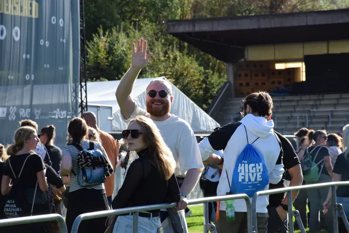 Ein lächelnder Mann mit rotem Bart und Sonnenbrille winkt auf dem Bautz-Festival.