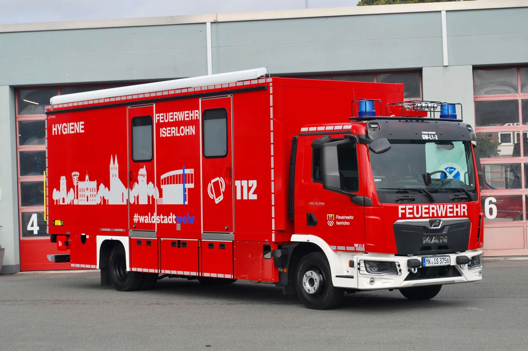 Rotes Feuerwehrfahrzeug der Feuerwehr Iserlohn mit der Aufschrift „HYGIENE“, das als mobile Hygiene- und Umkleideeinheit dient.
