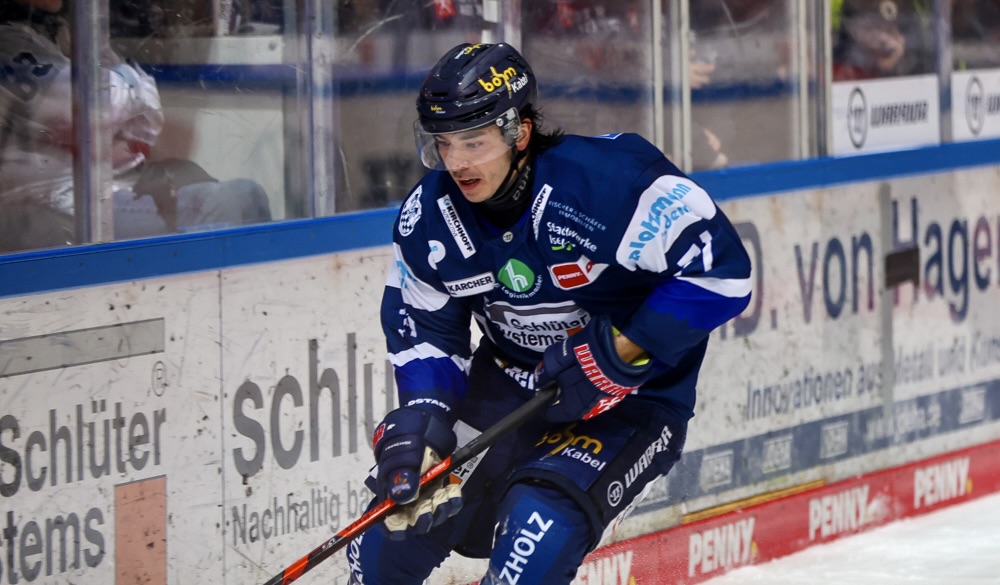 Eishockeyspieler Daniel Fischbuch in blauer Ausrüstung mit Schläger während eines Spiels.