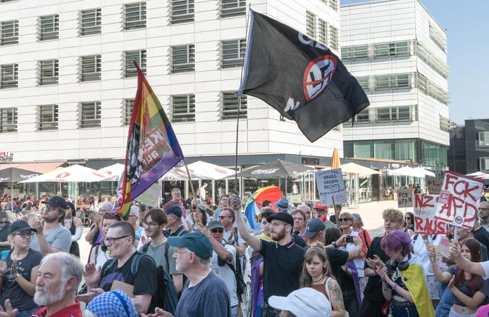 Demonstranten bei einer Kundgebung in Lüdenscheid halten eine Antifa-Flagge, eine Regenbogenfahne und Schilder gegen die AfD hoch.