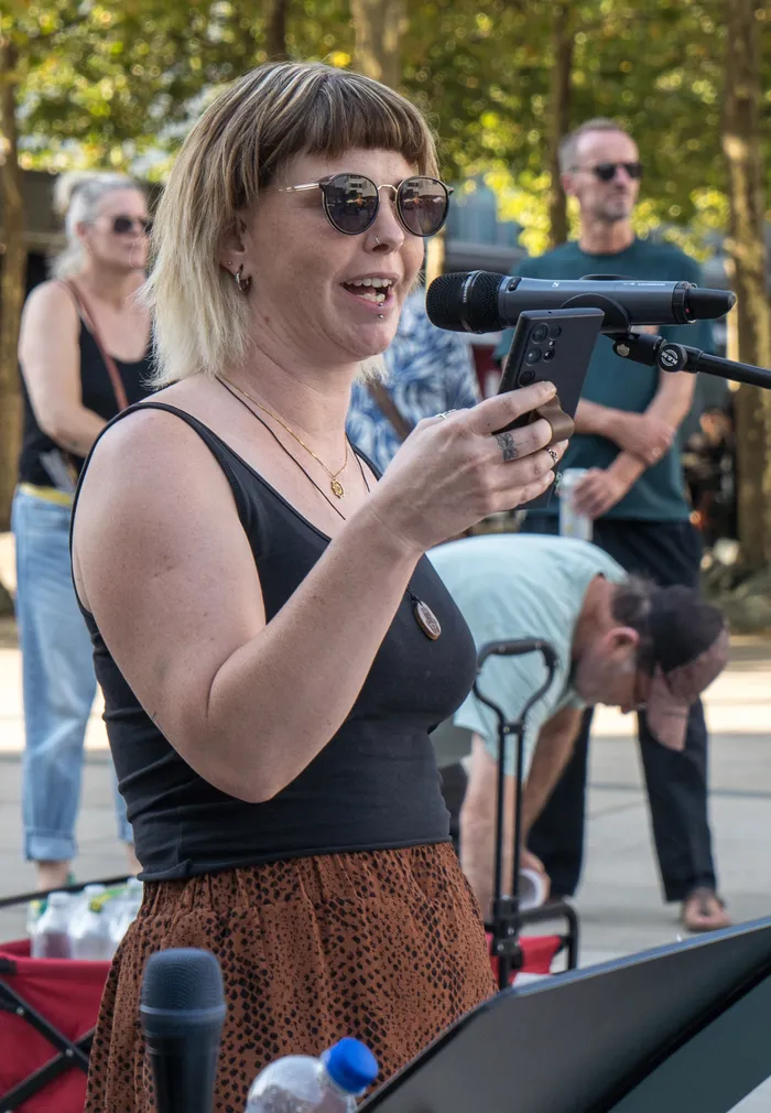 Jenny von march&resist spricht bei einer Kundgebung gegen die AfD in ein Mikrofon.