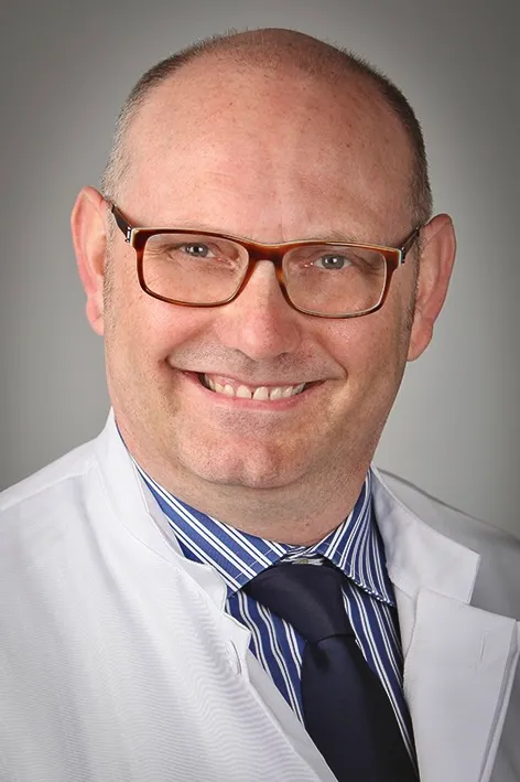 Porträt von Dr. Sven Schröder, dem neuen Direktor der Klinik für Allgemein-, Visceral- und spezielle Visceralchirurgie, mit freundlichem Lächeln und im weißen Kittel.