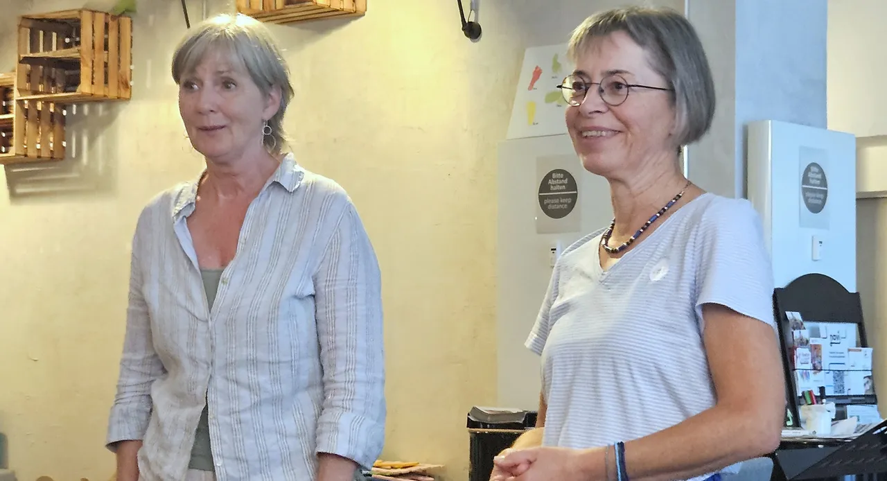 Andrea Bäcker und Susanne Wippermann stehen nebeneinander in einem hellen Raum.