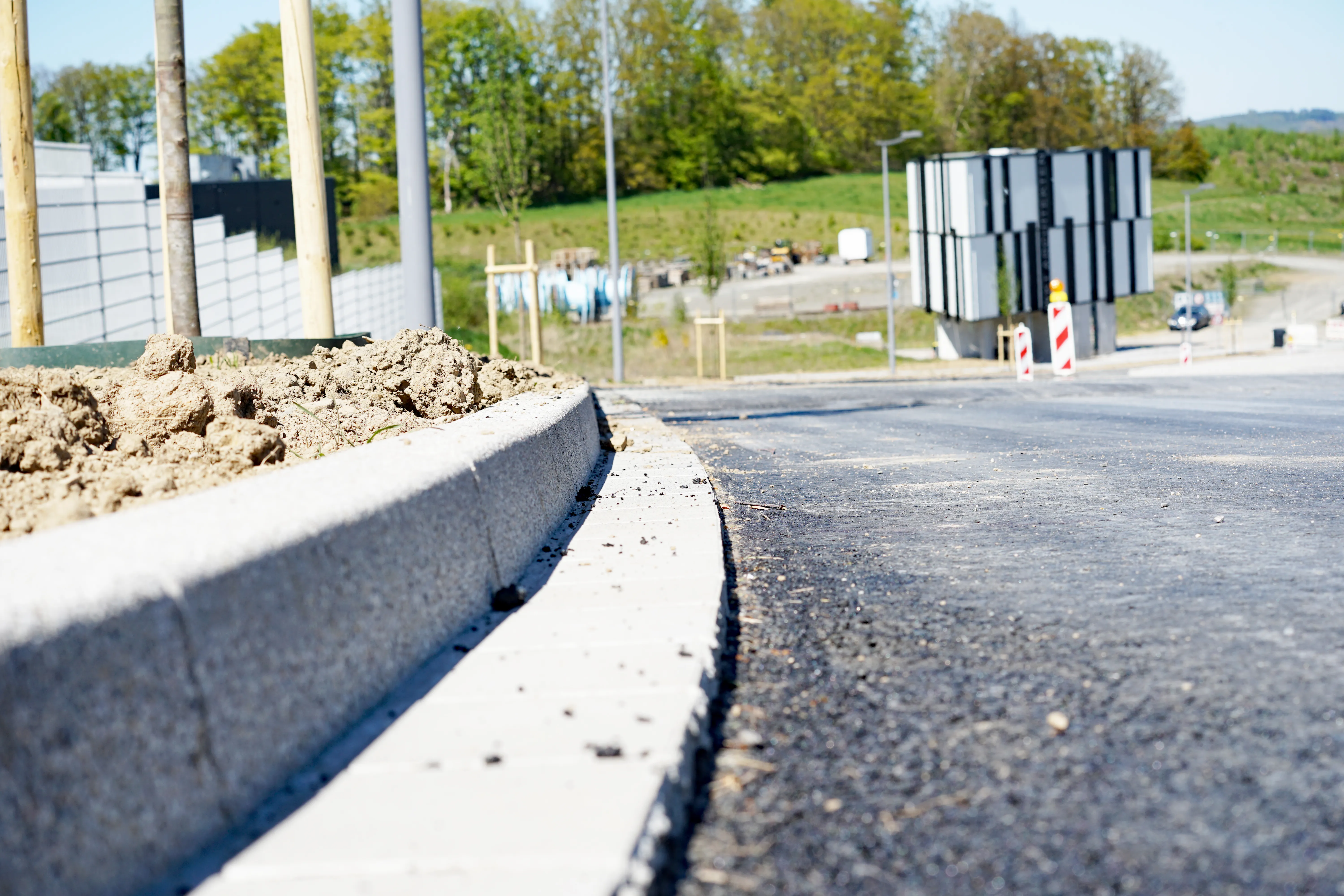 Neuer Bordstein an einer asphaltierten Straße im Gewerbepark Rosmart während der Bauarbeiten.