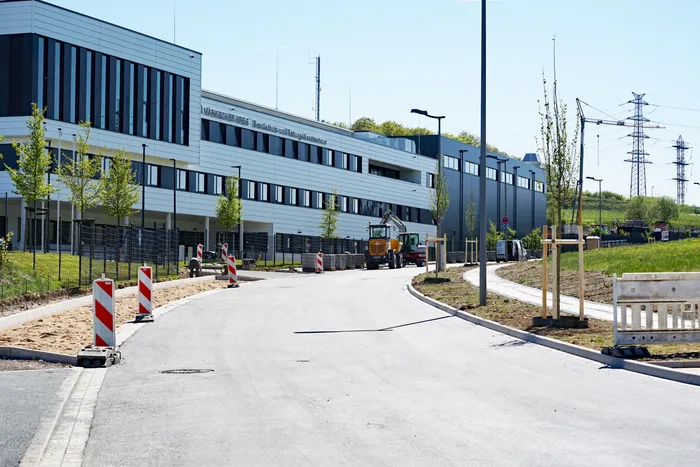 Neuer Gewerbepark Rosmart mit modernem, langgestrecktem Gebäude im Hintergrund und Bauarbeiten im Vordergrund.