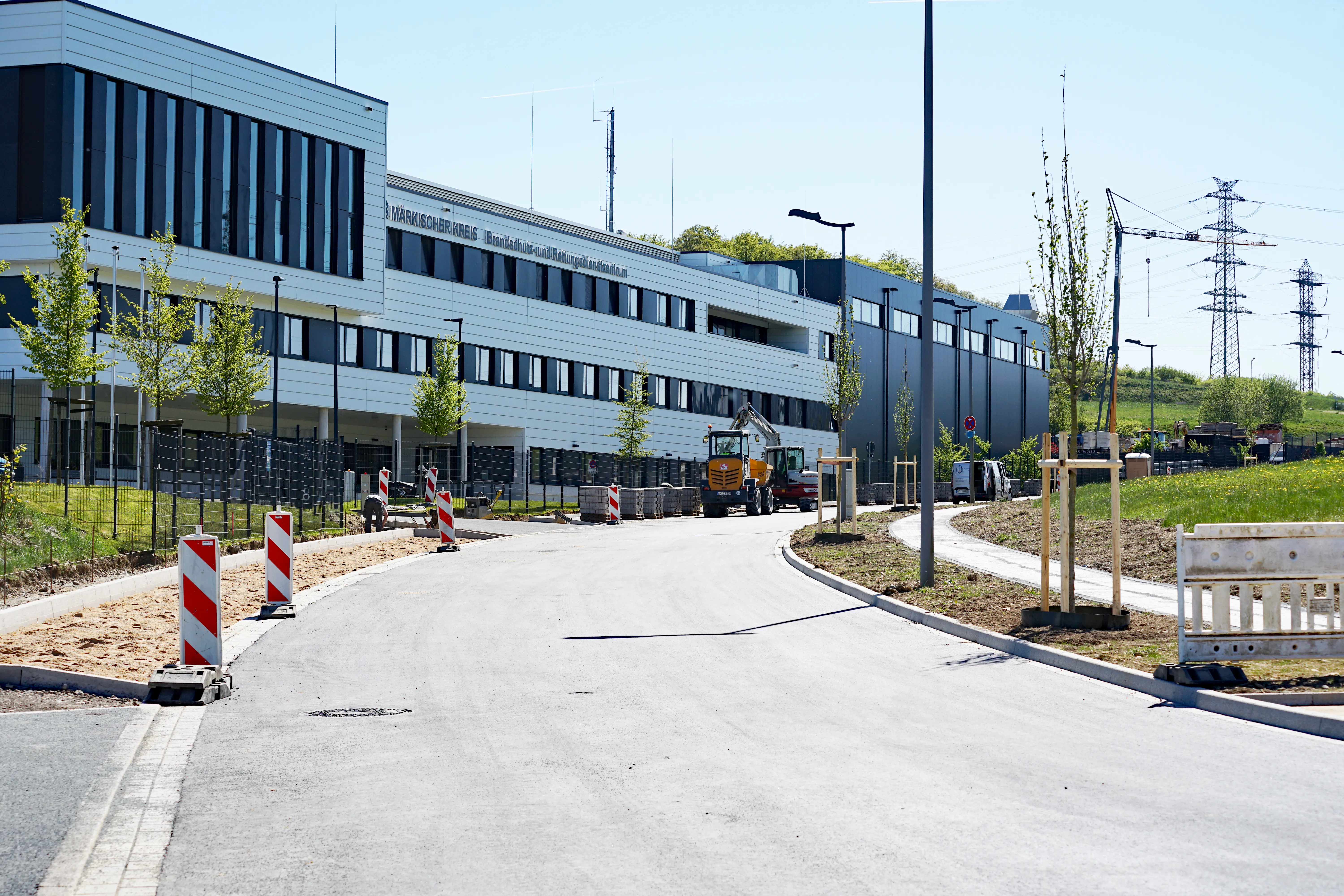 Neuer Gewerbepark Rosmart mit modernem, langgestrecktem Gebäude im Hintergrund und Bauarbeiten im Vordergrund.