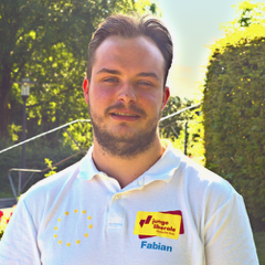 Fabian Bülow, Kandidat der FDP, trägt ein weißes Poloshirt mit Namensschild und EU-Flagge.