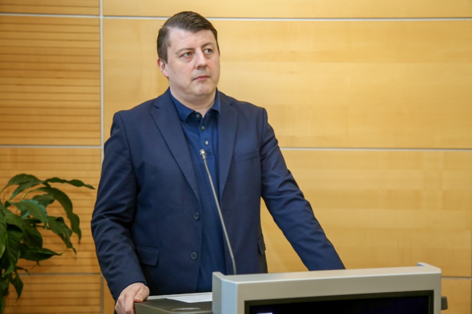 Fabian Ferber, SPD-Unterbezirks-Vorsitzender, spricht vor einem Podest in einem hellen Raum.