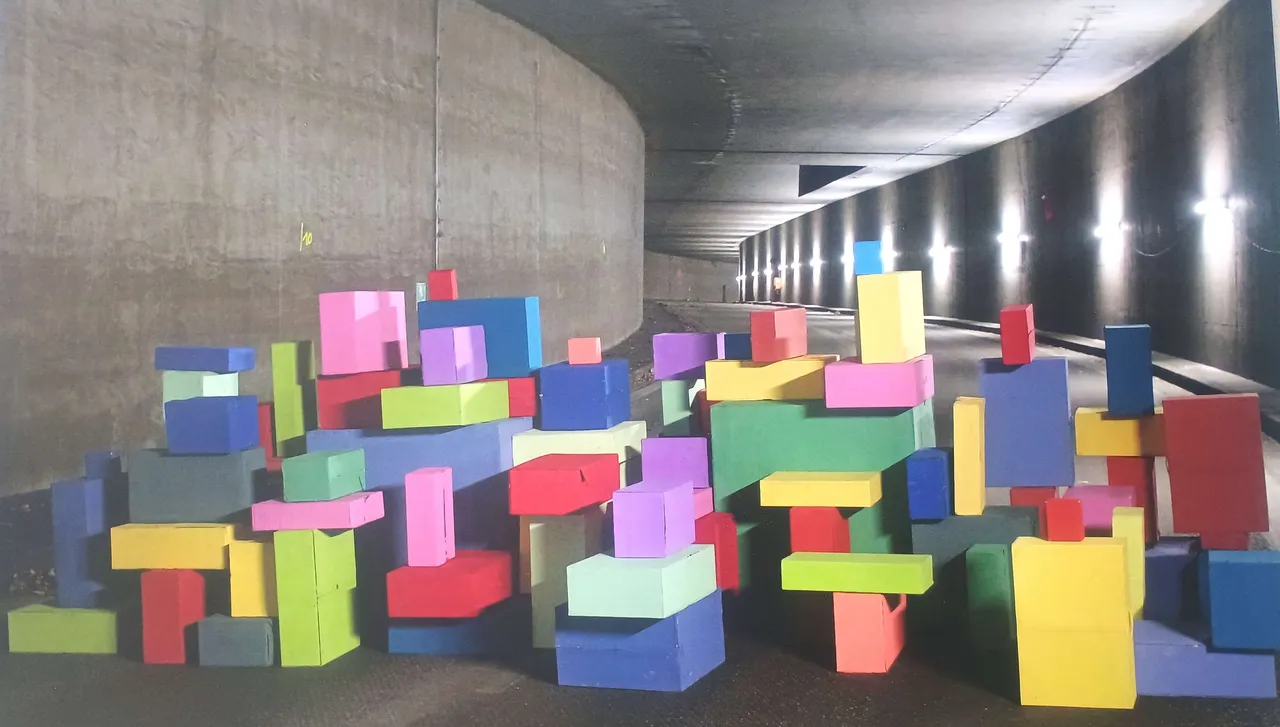 Bunte, quaderförmige Kartons versperren einen Fußgängertunnel. Das Kunstprojekt „Farbstapel“ der Schule an der Höh ist im Rathaustunnel aufgebaut.