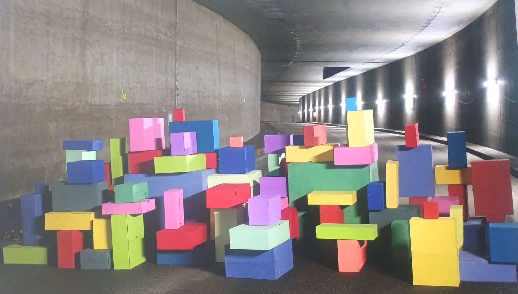 Bunte, quaderförmige Kartons versperren einen Fußgängertunnel. Das Kunstprojekt „Farbstapel“ der Schule an der Höh ist im Rathaustunnel aufgebaut.