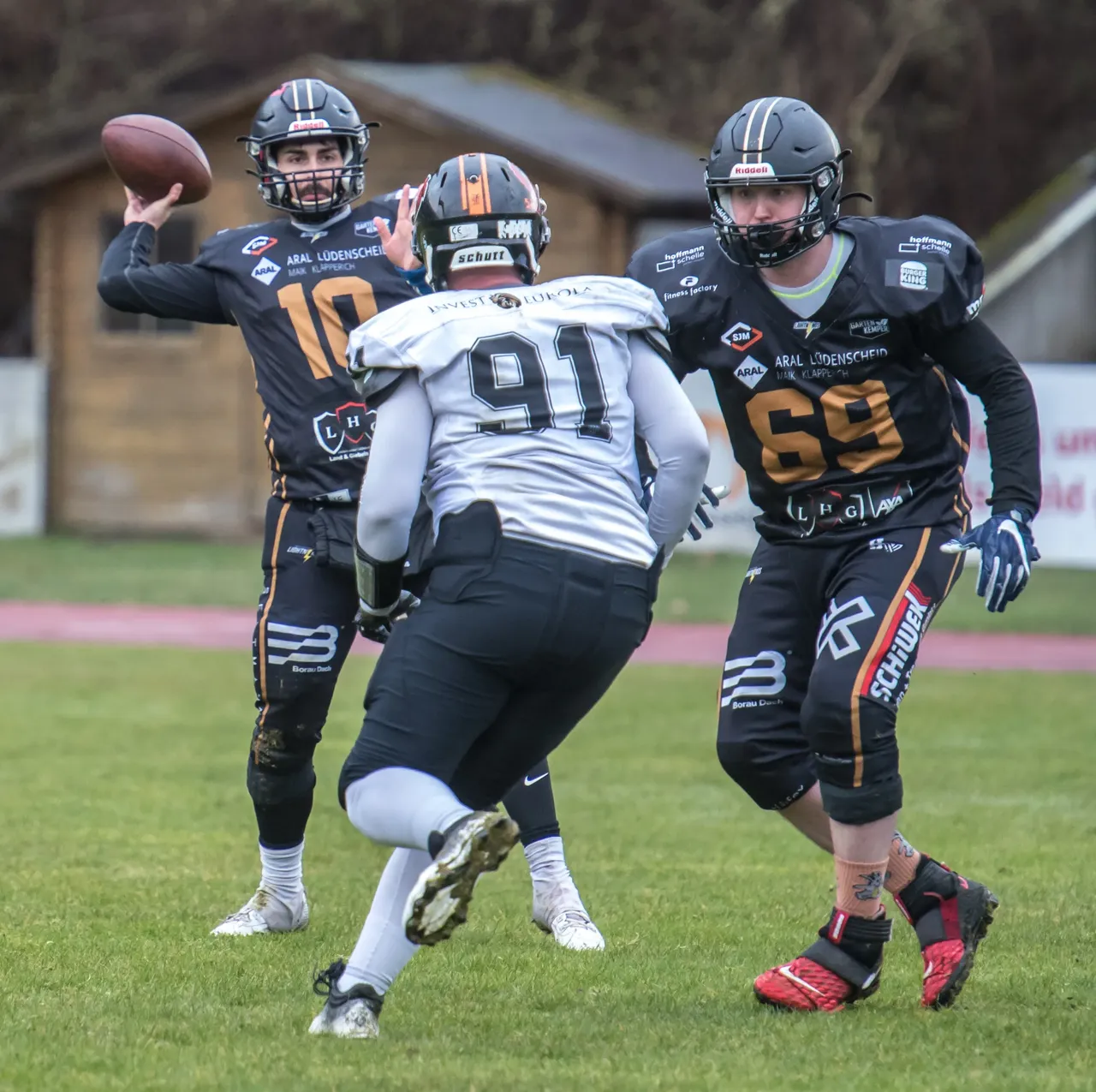 American-Football-Spieler der Lüdenscheid Lightnings in Aktion: Ein Quarterback wirft den Ball, während ein Gegenspieler versucht, ihn zu stoppen.