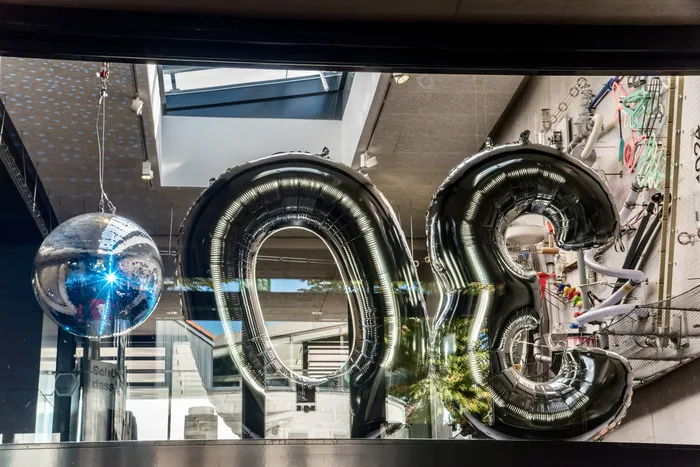 Große silberne Folienballons und eine Discokugel in einer Fensterdekoration zum 30-jährigen Jubiläum des Museums Phänomenta.