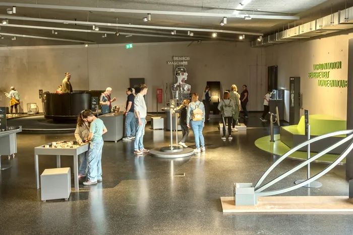 Besucher interagieren mit interaktiven Exponaten in der Ausstellungshalle des Erlebnismuseums Phänomenta.