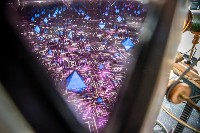 Digitale Installation mit leuchtenden blauen Pyramiden über einem violetten Linienmuster, betrachtet durch eine dreieckige Öffnung.