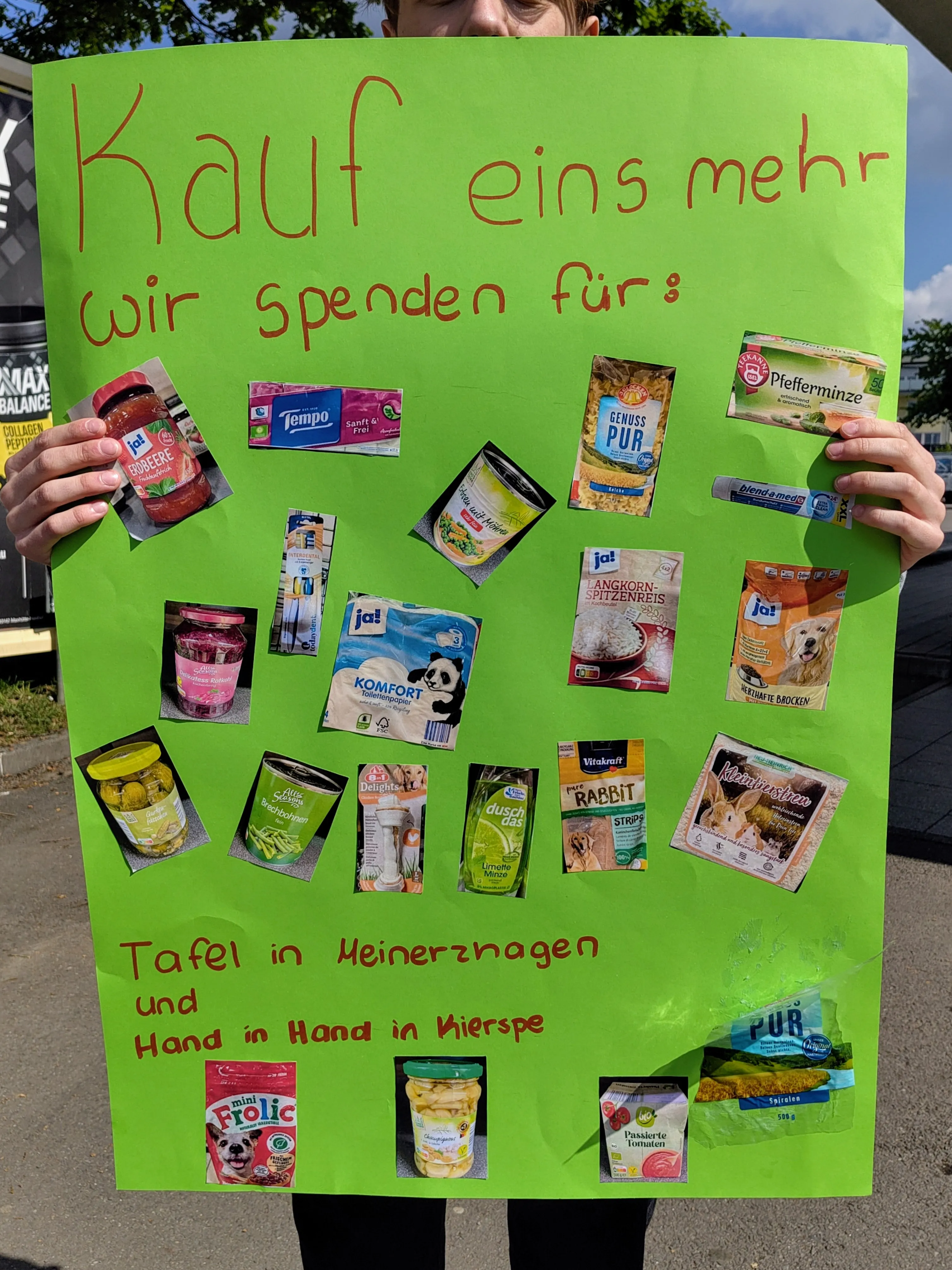 Grünes Plakat mit verschiedenen Tiernahrungsprodukten und dem Aufruf, für die Tafeln in Meinerzhagen und Kierspe zu spenden, wenn man selbst einkauft.