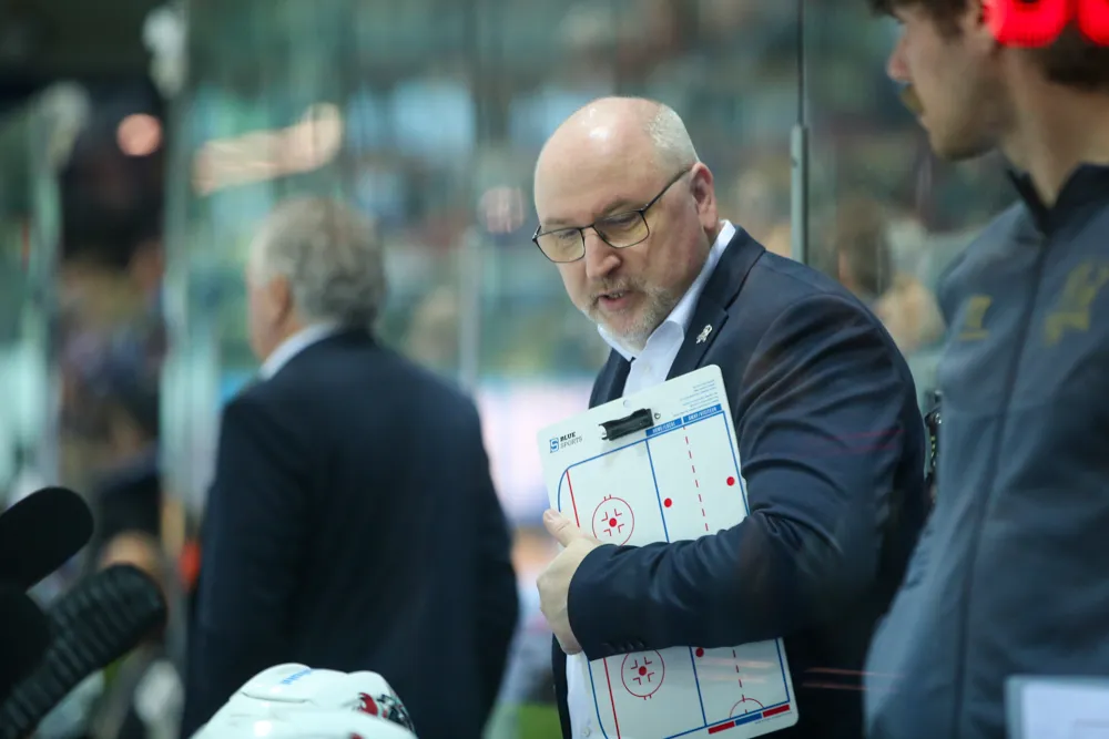 Frank Fischöder, damals Cheftrainer der Sauerländer, konzentriert sich auf eine Taktiktafel am Spielfeldrand.
