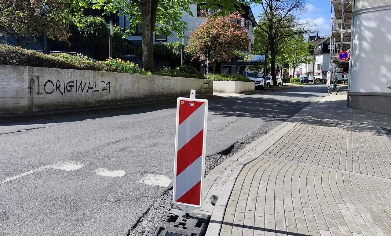 Straßenschild warnt vor Straßenschäden auf der Freiherr-vom-Stein-Straße, während im Hintergrund die Sanierungsarbeiten vorbereitet werden.