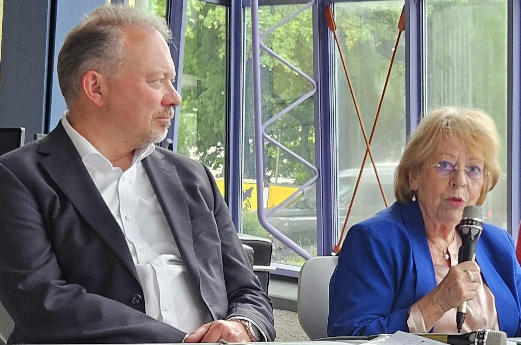 Dr. Arnhild Scholten, Vorsitzende des GHV Lüdenscheid, spricht in ein Mikrofon, während Markus Hacke, Kassierer des Vereins, neben ihr sitzt.