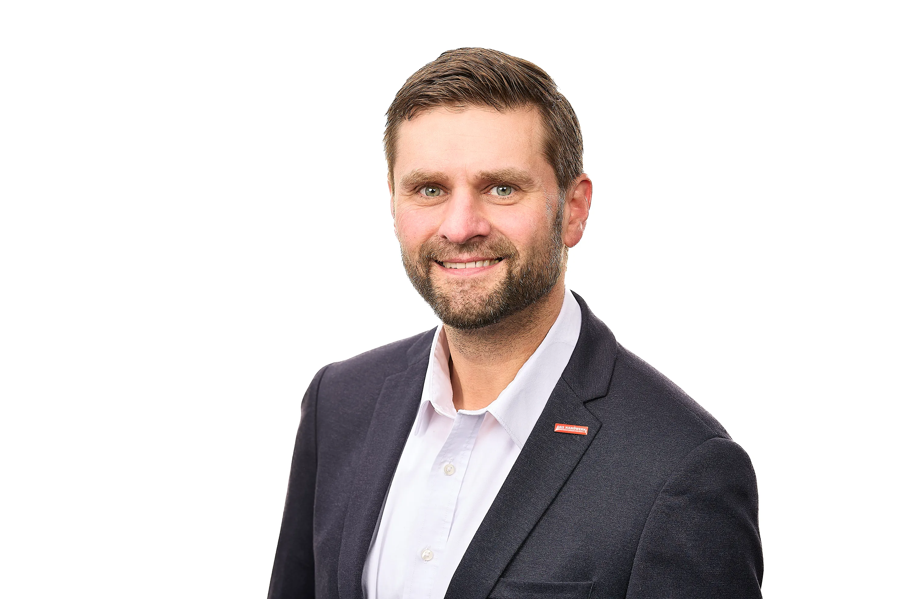 Porträt von Hendrik Schmitt, Hauptgeschäftsführer der Handwerkskammer Südwestfalen, mit freundlichem Gesichtsausdruck und Anzug.