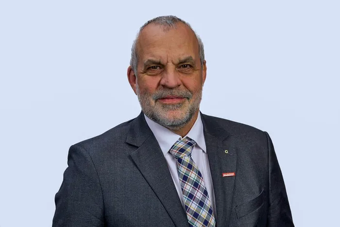 Jochen Renfordt, Präsident der Handwerkskammer Südwestfalen, trägt einen grauen Anzug und eine karierte Krawatte.