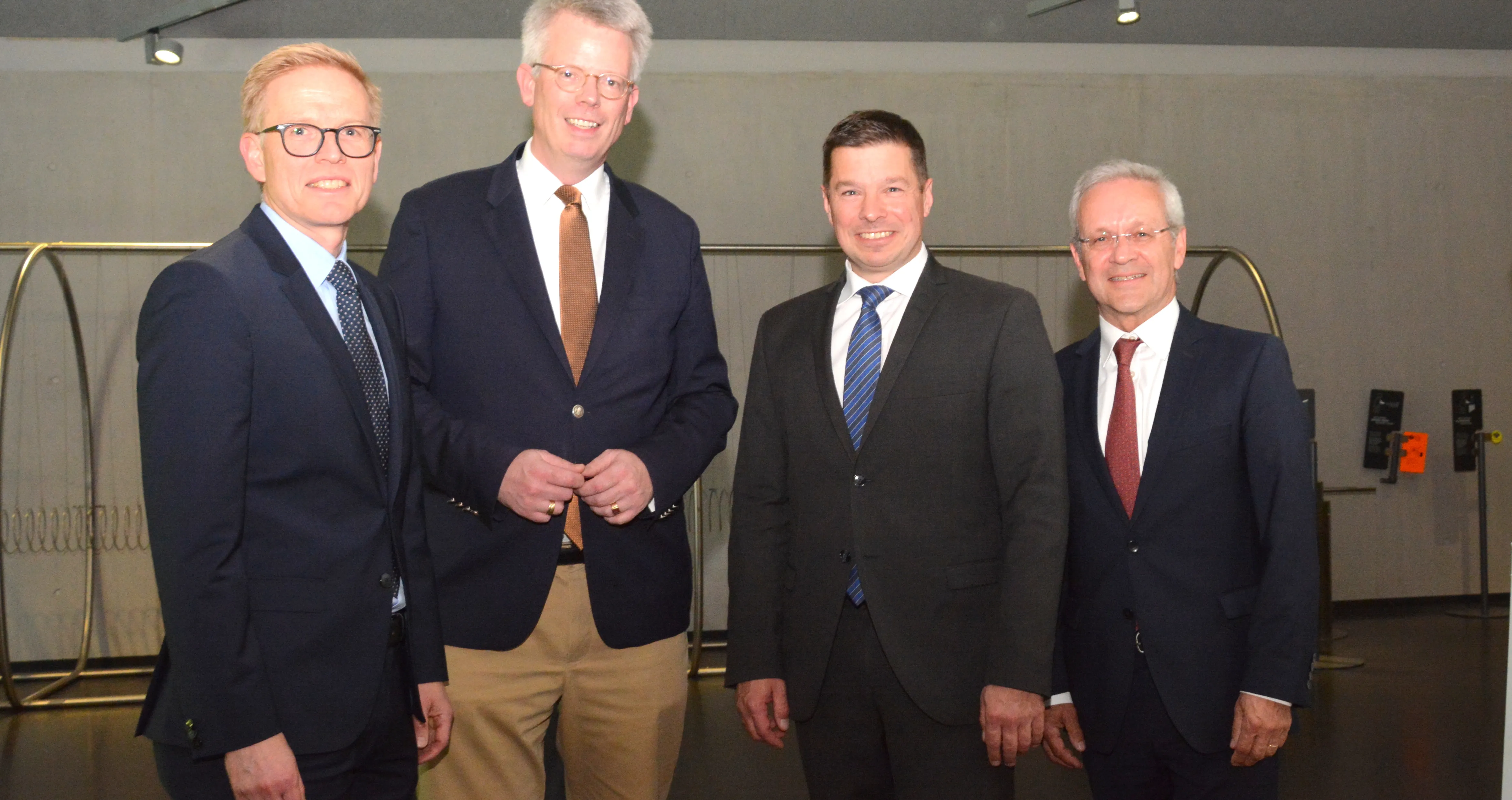 Vier Männer in Anzügen stehen nebeneinander und lächeln in eine Kamera. Von links nach rechts: Christian Lepping, Prof. Dr. Hubertus Bardt, Andreas Kostal und Dr. Frank Hoffmeister.