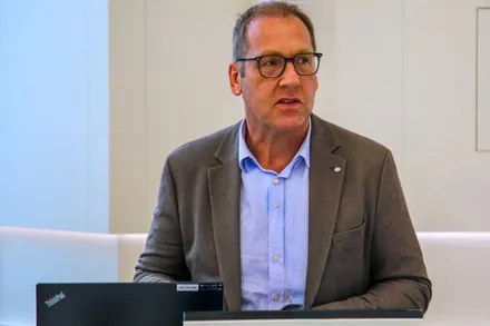 Hubertus Winterberg, ein Mann mit Brille und grau meliertem Haar, trägt Jackett und blaues Hemd und spricht in die Kamera.