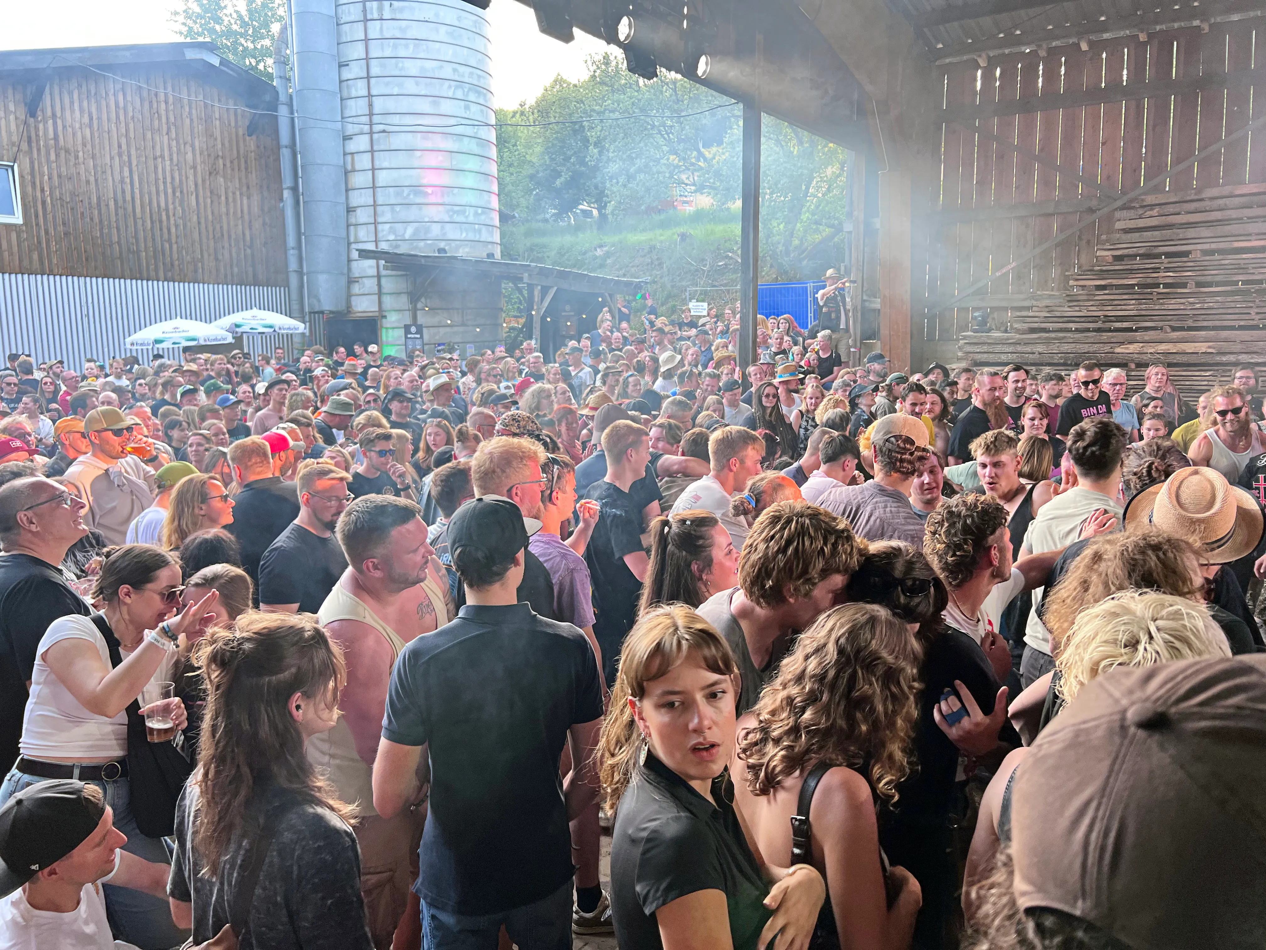 Große Menschenmenge vor einer Bühne auf dem Immecke Rock Festival in Plettenberg. Viele Besucher tragen Caps und feiern.