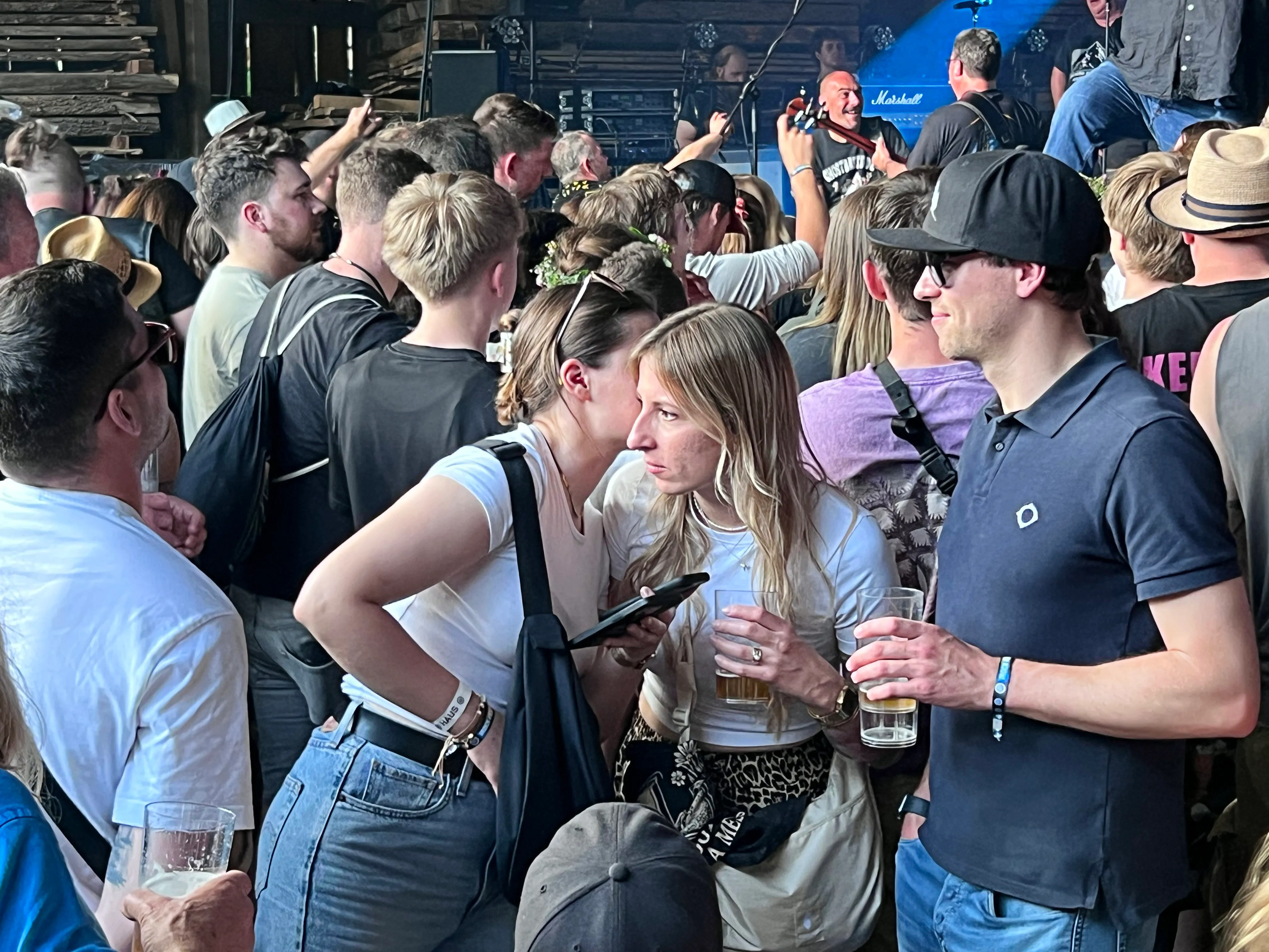 Menschenmenge auf dem I-Rock-Festival in Plettenberg, viele halten Getränke in der Hand und schauen in Richtung Bühne.