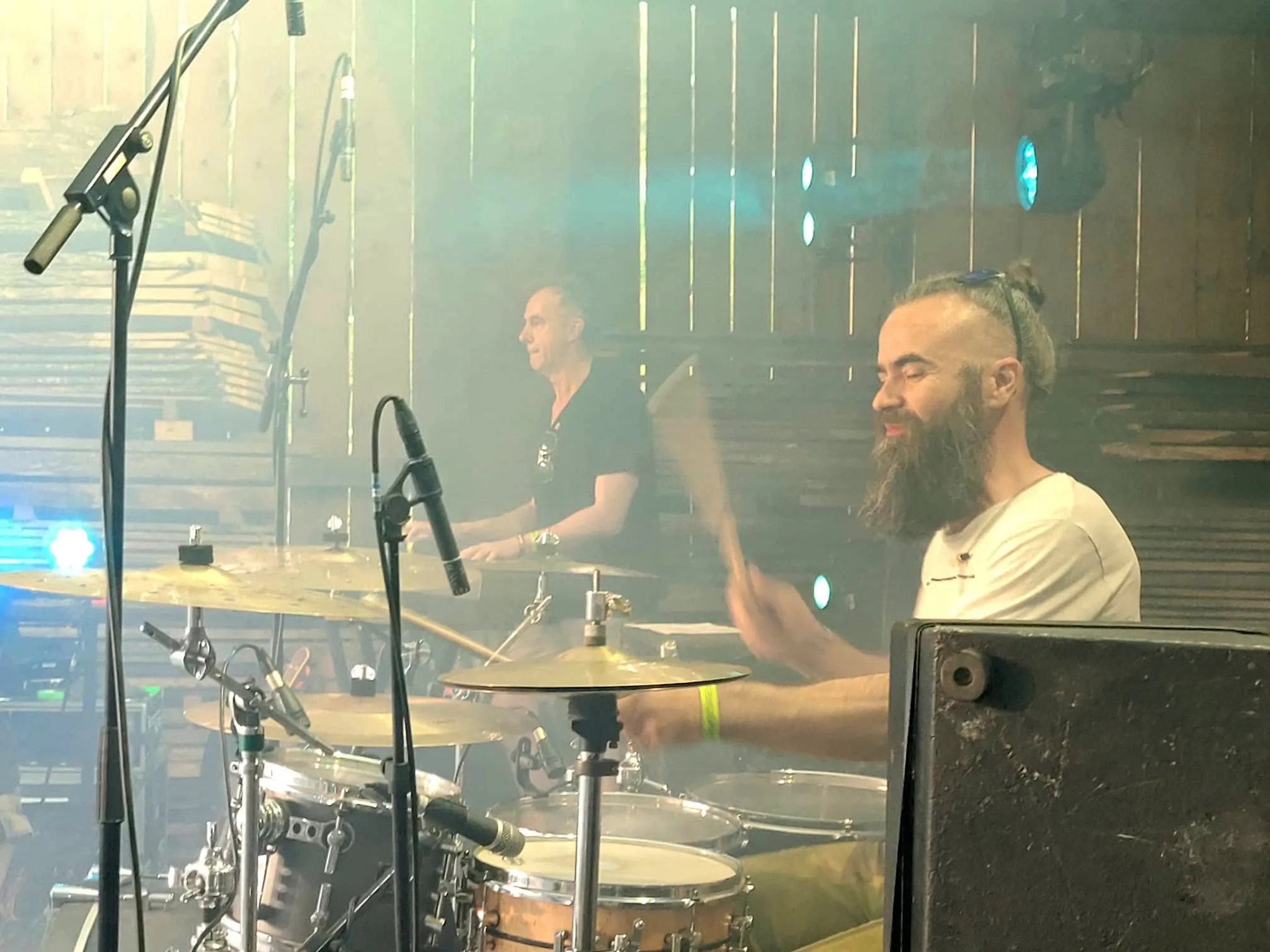 Zwei Musiker spielen Schlagzeug auf einer Bühne im Freien, während sie sich während eines Konzerts auf dem I-Rock-Festival in Plettenberg zuwenden.