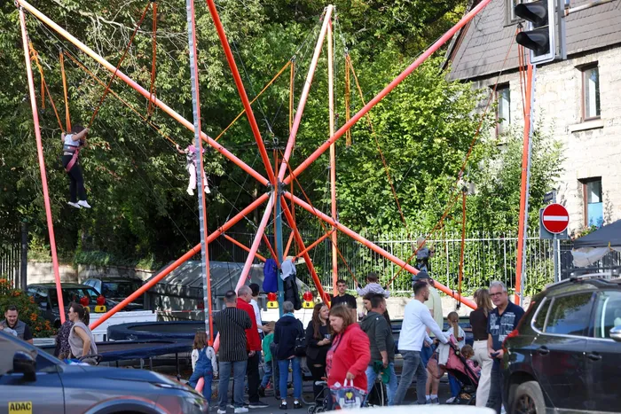 Menschen nutzen eine große, orangefarbene Kletterkonstruktion beim Brückenfest 2026.