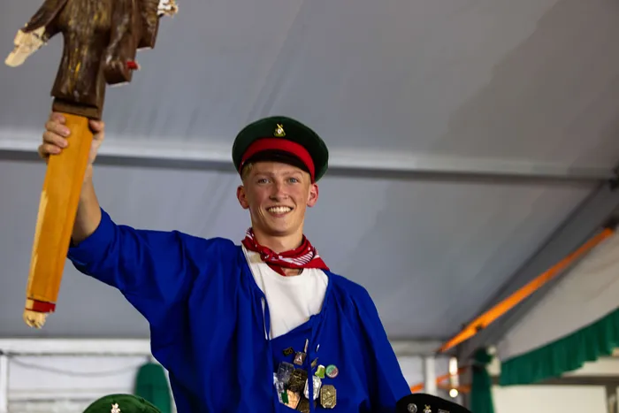 Luca Benninghaus, der neue Jungschützenprinz der Schützengilde Meinerzhagen, hält das Prinzenzeichen in die Höhe.