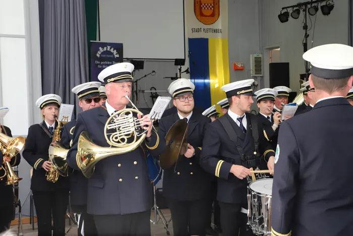 Musikzug des Schützenvereins Landemert spielt während des Schützenfestes. Mehrere Musiker in Uniformen spielen Blechblasinstrumente und Schlagzeug.