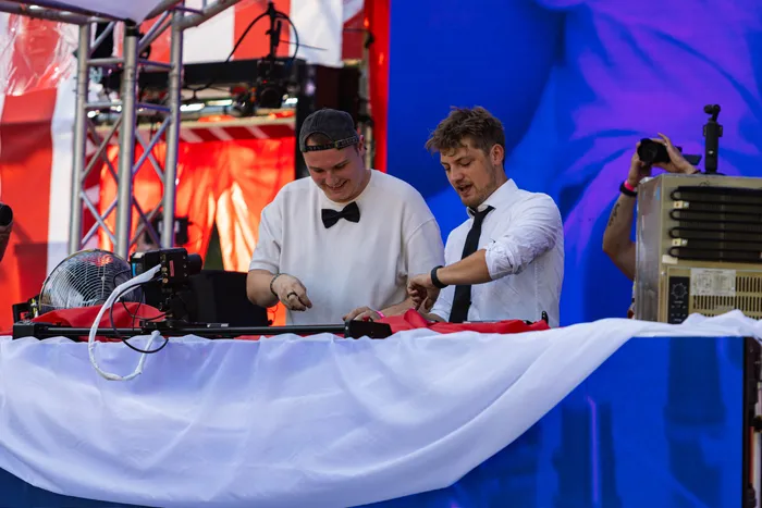 Zwei Männer in weißer Kleidung bedienen die Musiktechnik an einem DJ-Pult beim Ferik Festival.