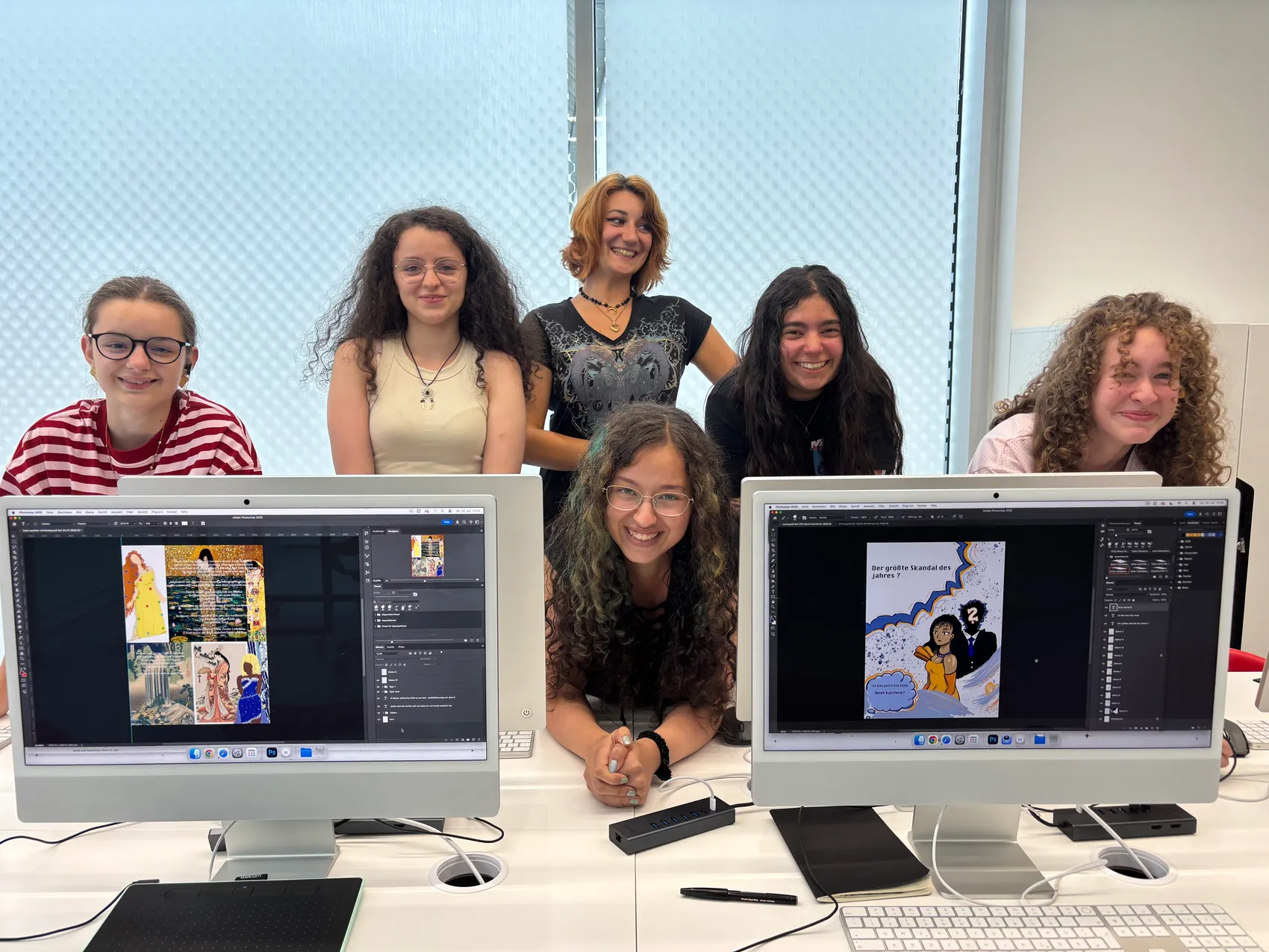 Sechs Jugendliche sitzen in einem Designstudio vor Computermonitoren, auf denen Magazin-Layouts zu sehen sind.
