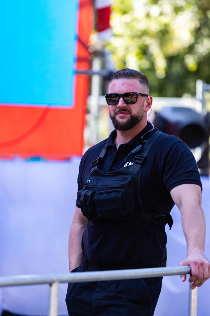 Ein bärtiger Mann mit Sonnenbrille und schwarzer Weste steht an einem Geländer beim Ferik Festival.