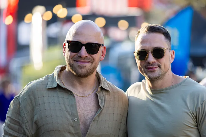 Zwei lächelnde Männer mit Sonnenbrillen stehen nebeneinander beim Ferik Festival.