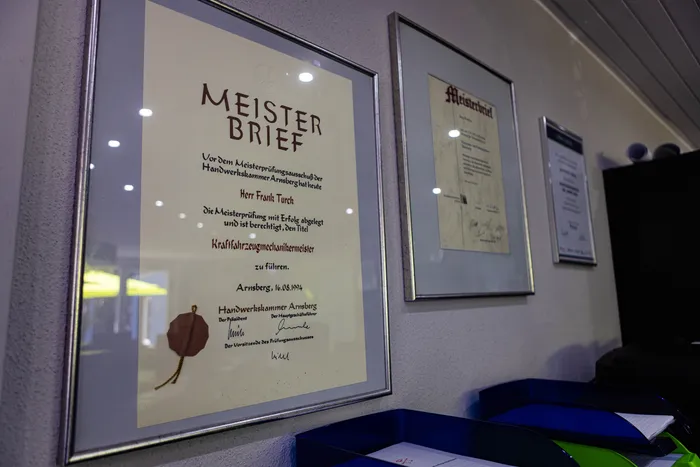 Gerahmtes Meisterbrief-Dokument an Frank Turck für das erfolgreiche Ablegen der Meisterprüfung im Kraftfahrzeugmechanikerhandwerk, ausgestellt von der Handwerkskammer Arnsberg am 16.08.1994.