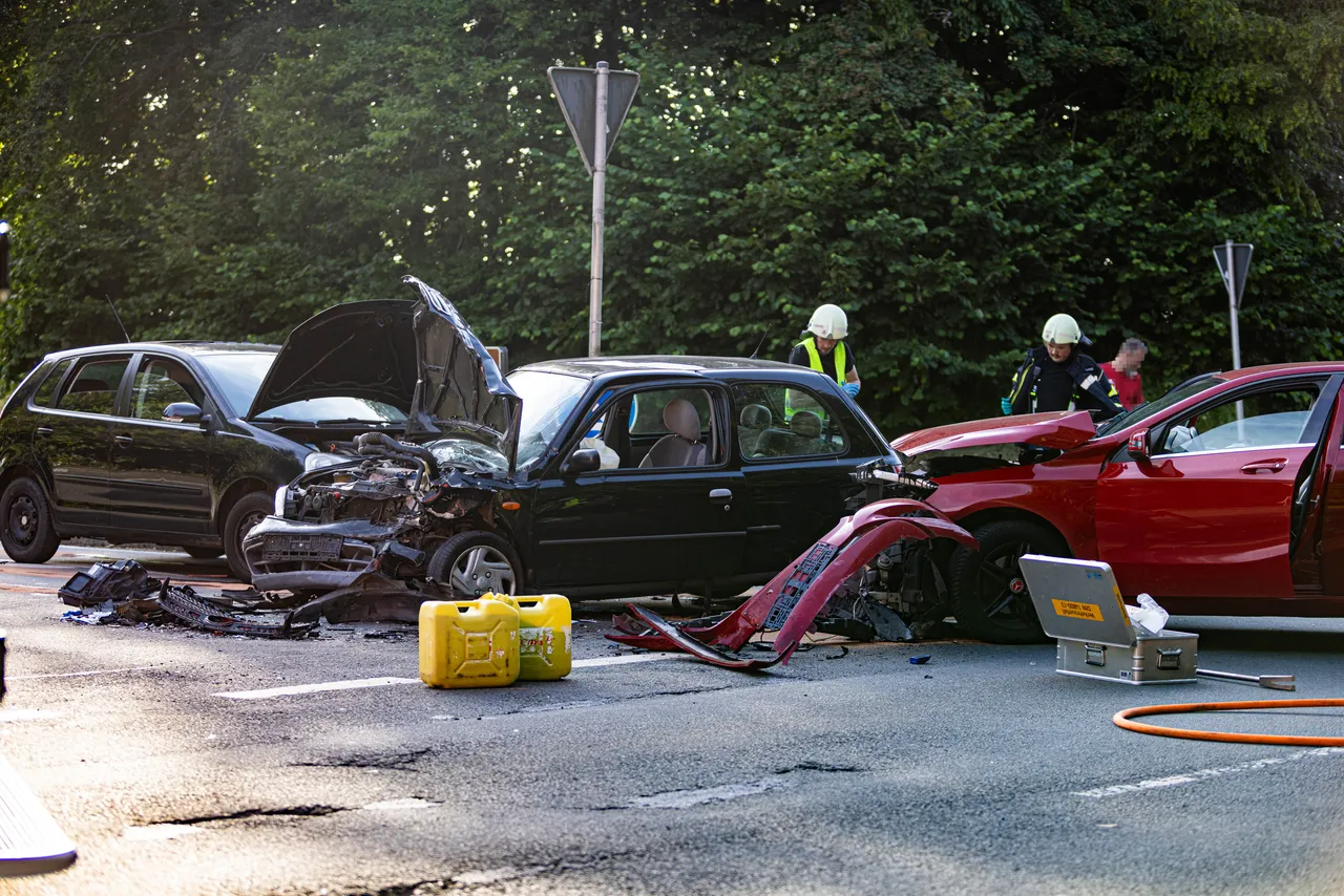 Mehrere stark beschädigte Autos blockieren eine Landstraße nach einem Unfall. Rettungskräfte sind vor Ort und kümmern sich um die Verletzten.
