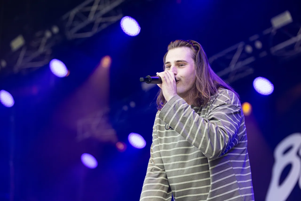 Baumgart singt in ein Mikrofon unter blauem Bühnenlicht auf dem Bautz-Festival 2026.