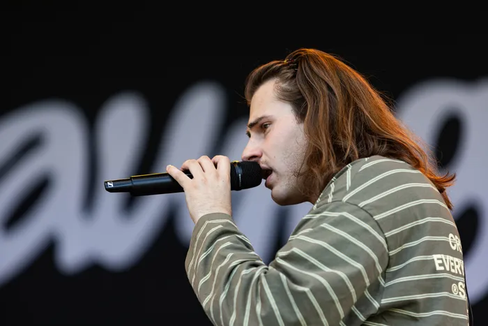 Baumgart singt mit langen braunen Haaren in ein Mikrofon auf der MainStage des Bautz-Festivals.