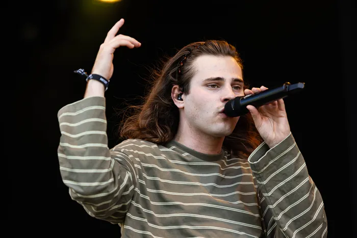 Baumgart singt mit erhobener Hand in ein Mikrofon auf der MainStage des Bautz-Festivals.